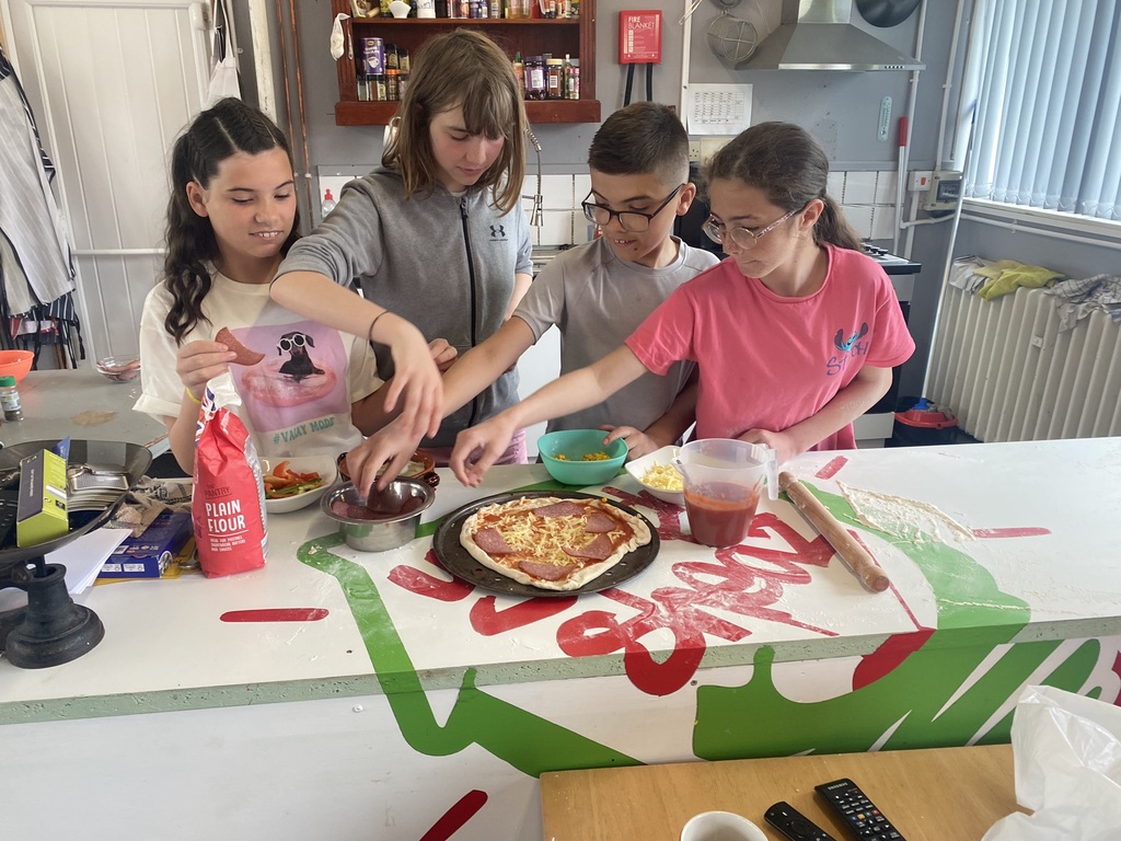 Four young people at Abergele Youth Den learning how to cook by making pizza's from scratch